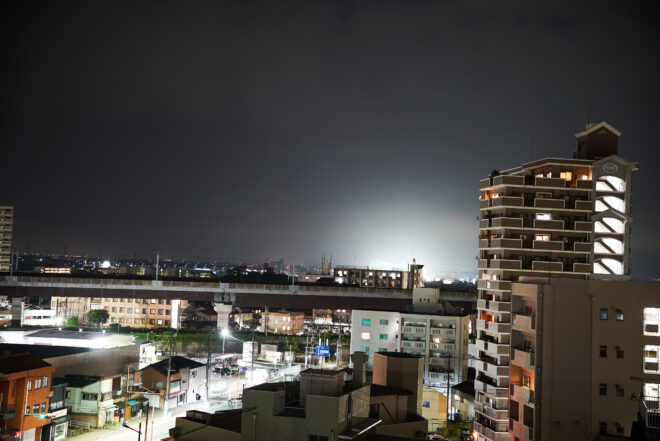 夜の住宅街とビル群が広がる市街地の風景