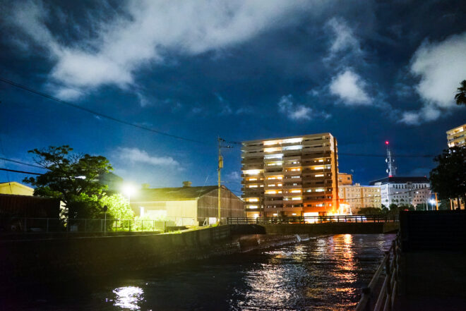 夜の川辺とマンション街