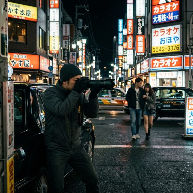 福岡のネオン街で密会する対象者を物陰から撮影するクローバー探偵事務所の調査員